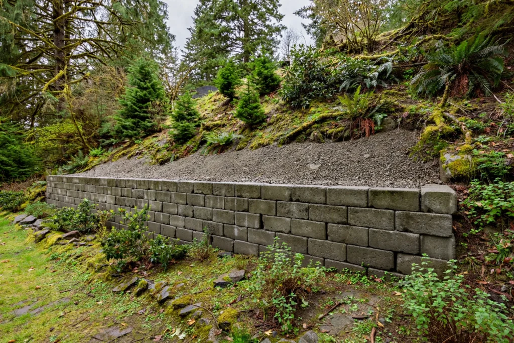 retaining wall installation cost BC — concrete block retaining wall with drainage in a sloped BC yard